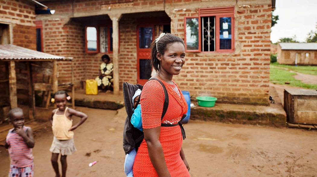 villager in front of home with children playing